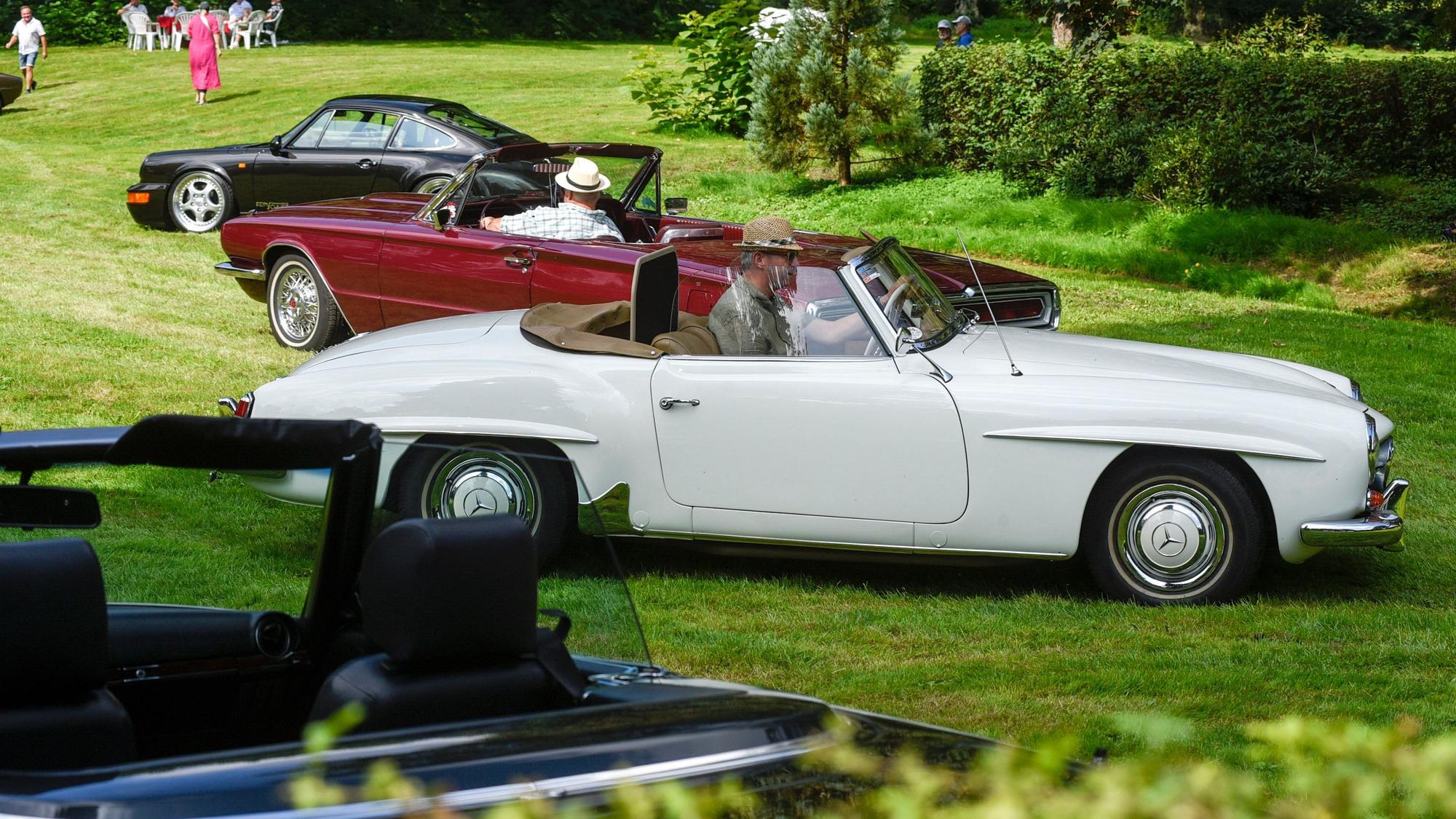 Drei Oldtimer stehen im Park des Schlosses Loersfeld.