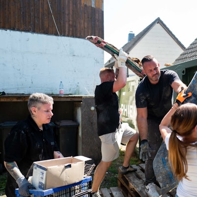 Das Bild zeigt einige Helfer, die ausrangierten Hausrat entsorgen.