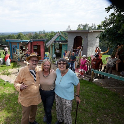 Auf einer Wiese vor dem Skulpturenpark stehen Paul und Rita Greven. In ihrer Mitte: Bürgermeisterin Sabine Preiser-Marian