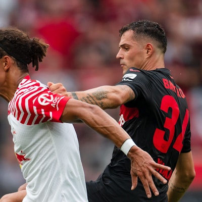 Leverkusens Granit Xhaka (r) und Leipzigs Yussuf Poulsen kämpfen um den Ball.