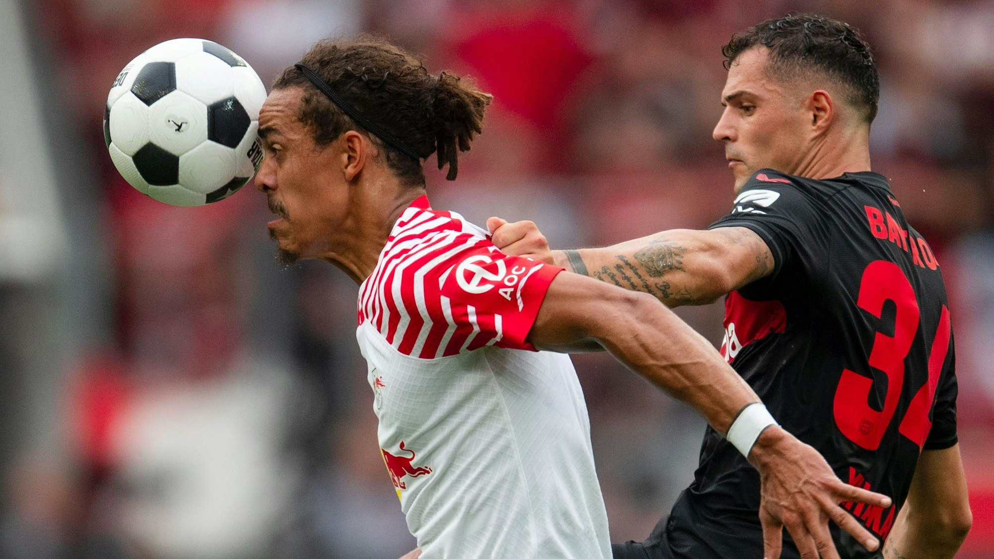 Leverkusens Granit Xhaka (r) und Leipzigs Yussuf Poulsen kämpfen um den Ball.