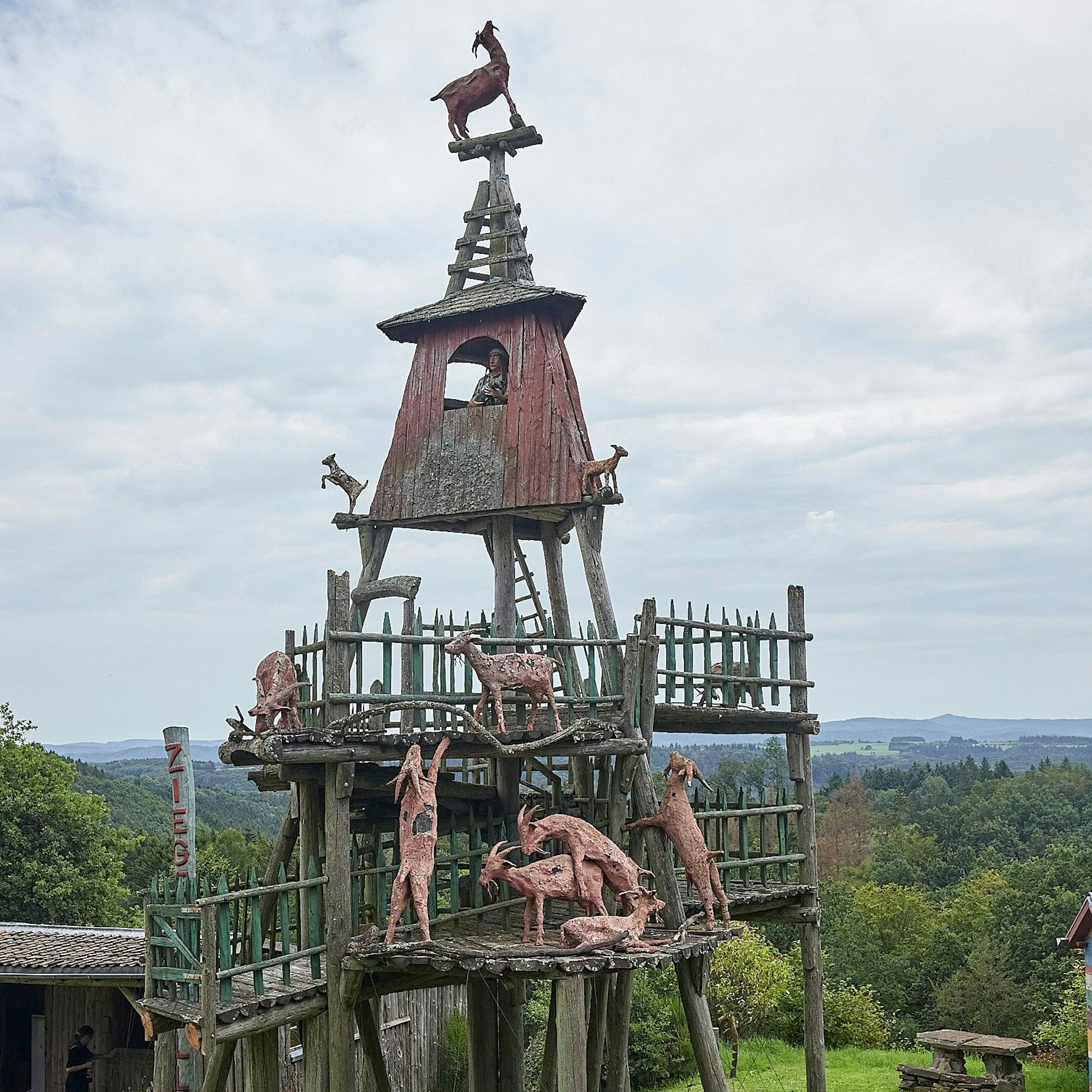 Das Bild zeigt einen Turm, auf dem sich Ziegenskulpturen befinden.