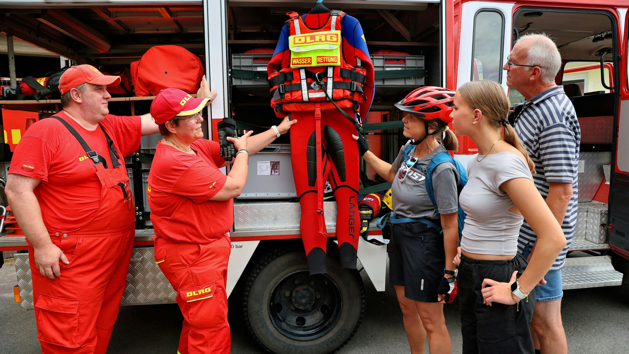 Aktive der DLRG Leichlingen erklären etwas an ihrer Ausrüstung.