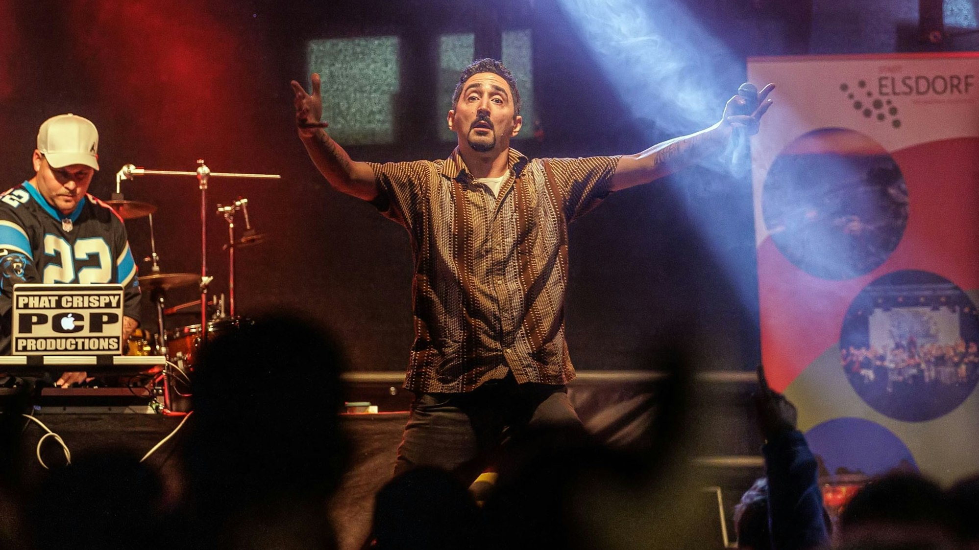 Eko Fresh steht auf einer Bühne und animiert das Publikum.