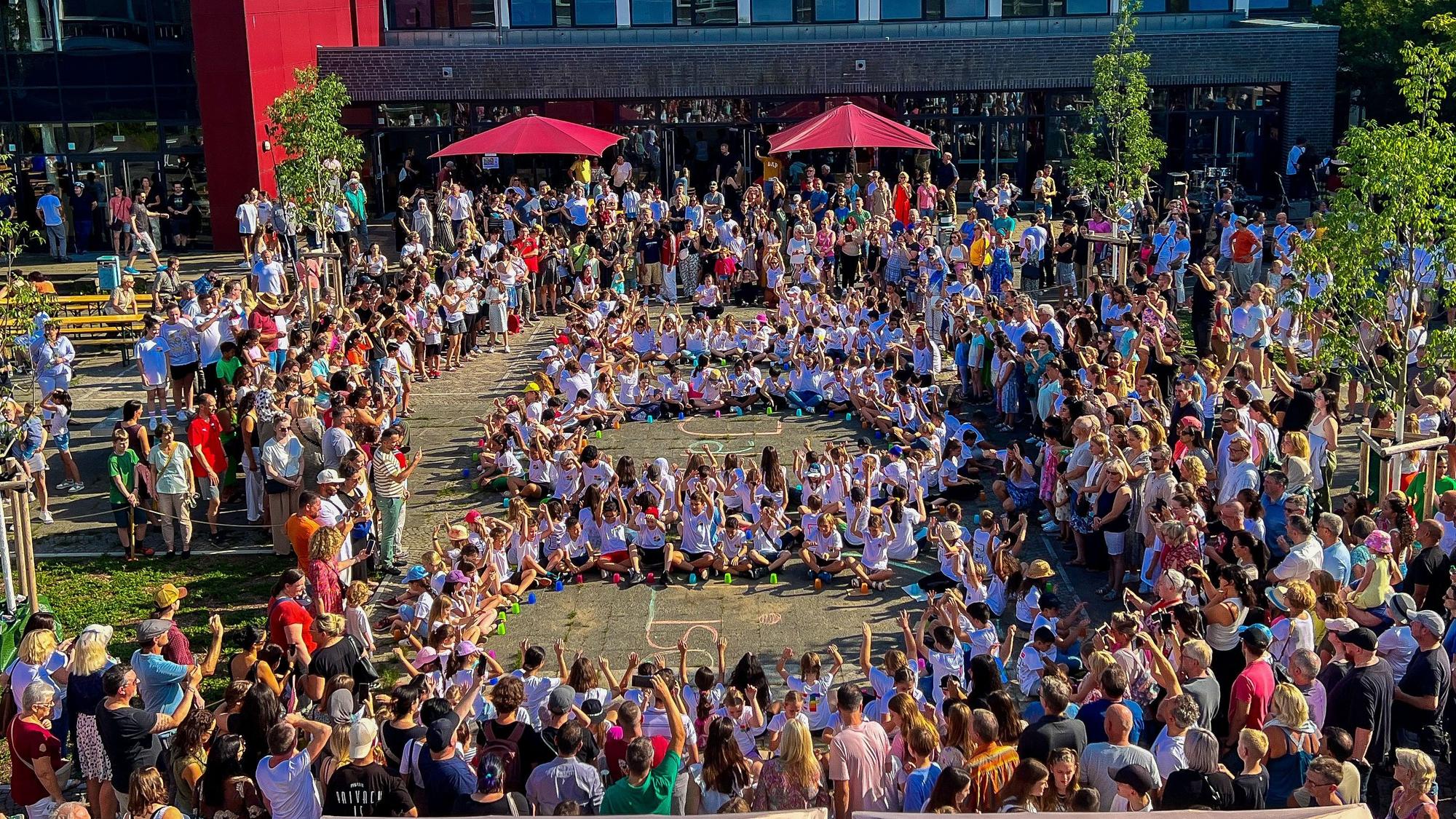 Schülerinnen und Schüler des Lise-Meitner-Gymnasiums formen eine 100 zum Jubiläum.