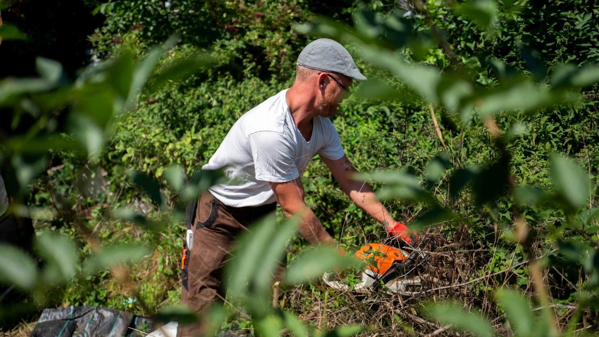 Das Bild zeigt einen Mann, der mit einer Kättensäge arbeitet.