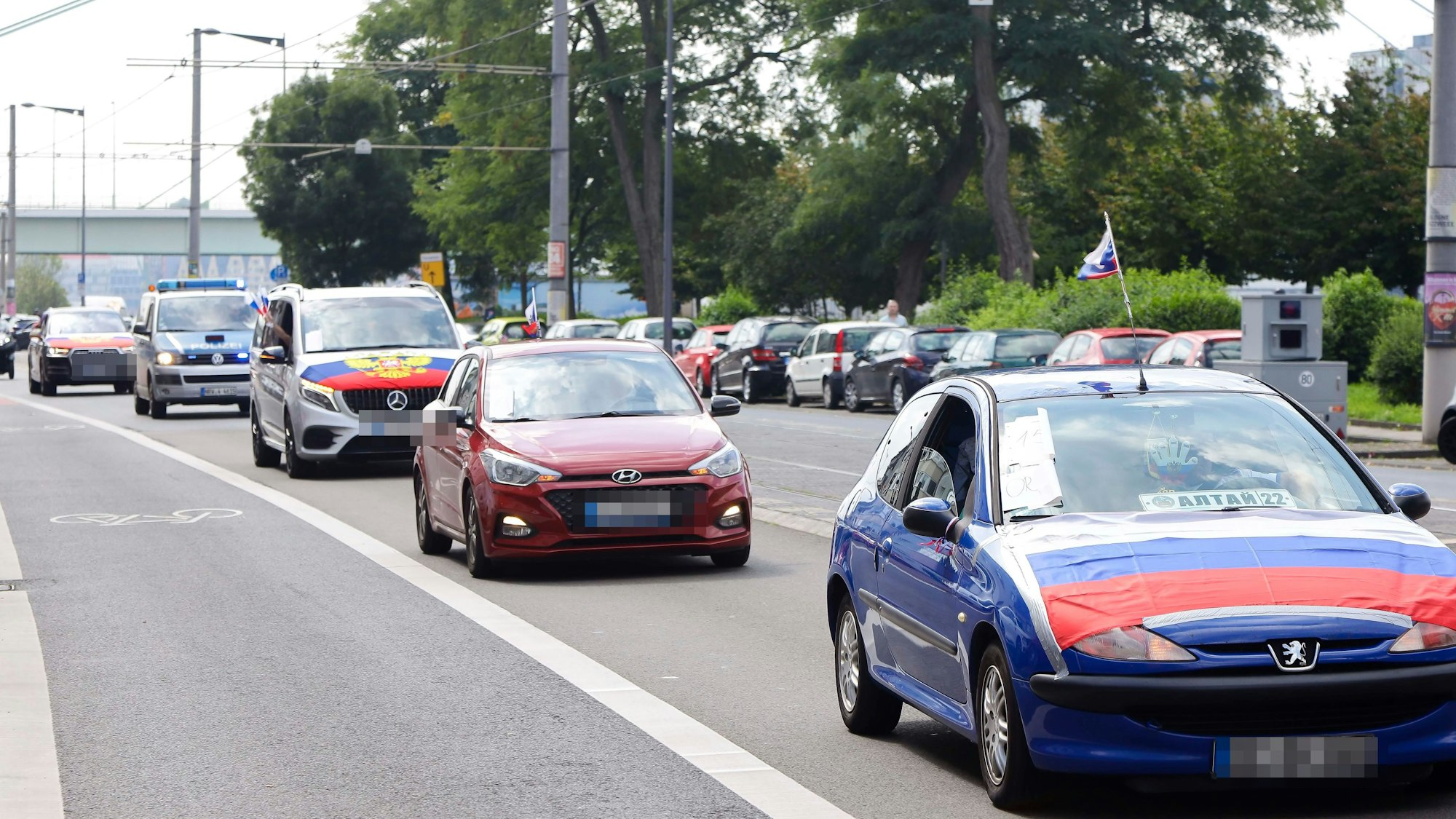 Teilnehmer des kurzen pro-russischen Autokorsos, der am Sonntag durch Köln rollte.