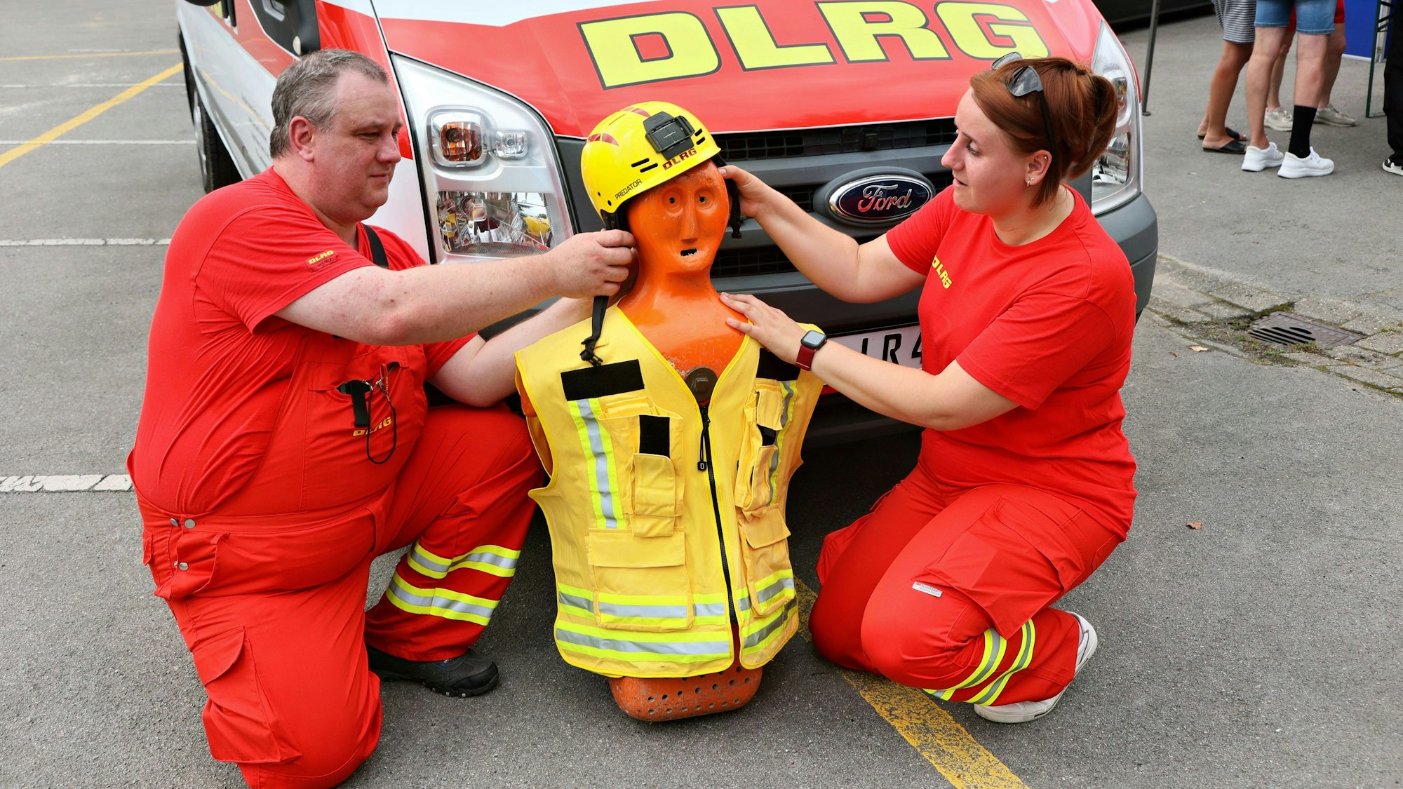 Alina und Michael vom Jugendeinsatzteam zeigen an einer Puppe, was im Dienst zu tun ist.