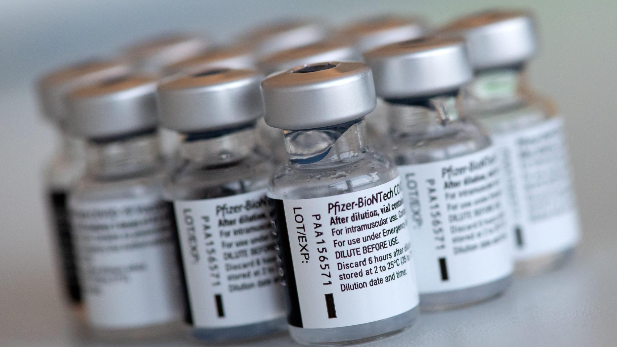 Leere Ampullen des Impfstoffs von Biontech/Pfizer gegen das Corona-Virus SARS-CoV-2 stehen in einem Impfzentrum nach der Vorbereitung der Spritzen auf einem Tisch.