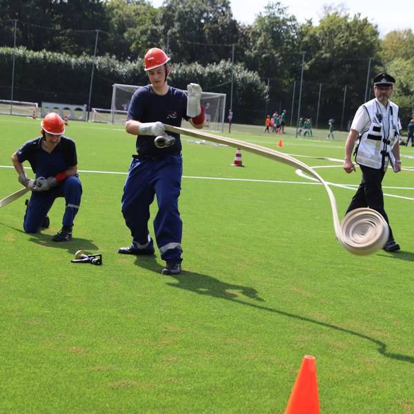 23 Jugendfeuerwehrgruppen traten in Hennef auf dem Gelände von Schul- und Sportcampus zur Abnahme der Leistungsspange an. Bei der feuerwehrtechnischen Übung mussten sie Schläuche ausrollen und aneinander kuppeln.