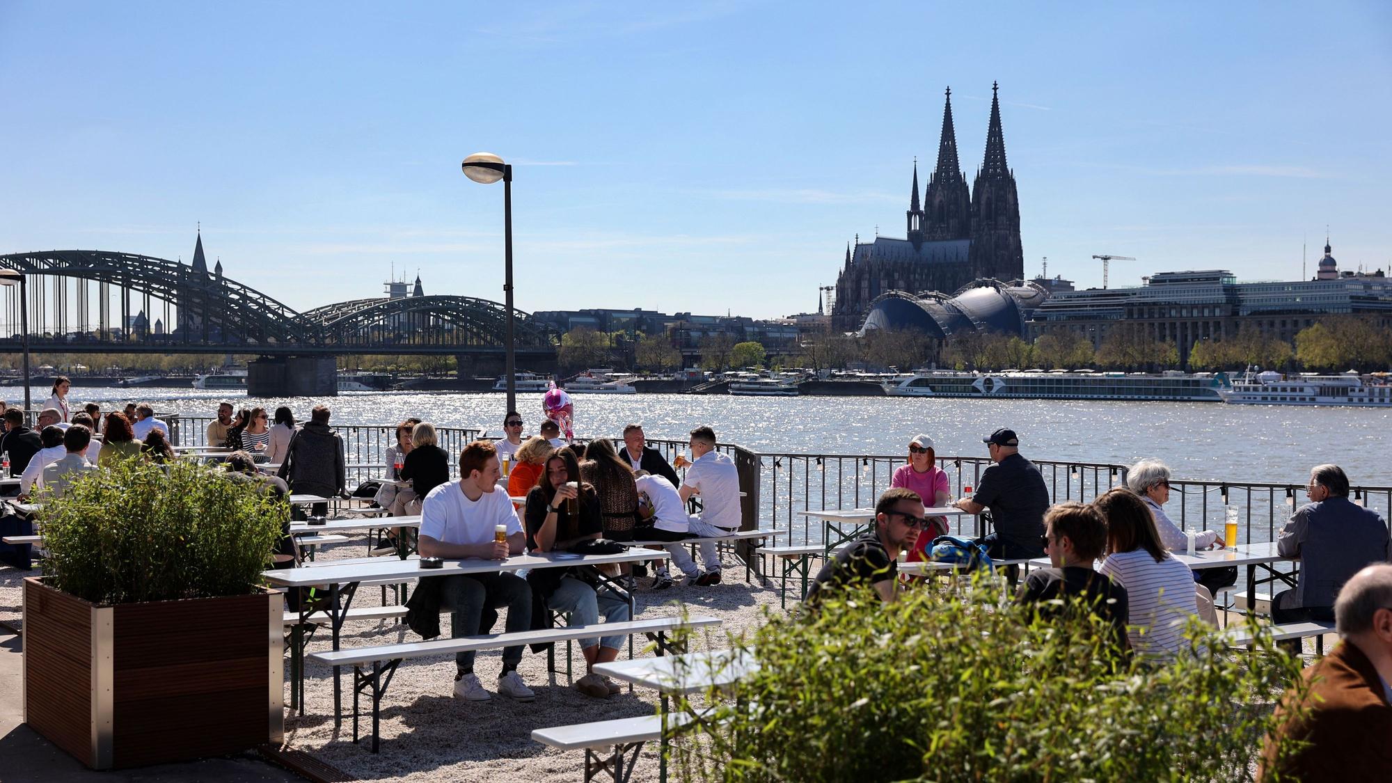 Gäste sitzen im Sommer im Biergarten der Rheinterrassen.