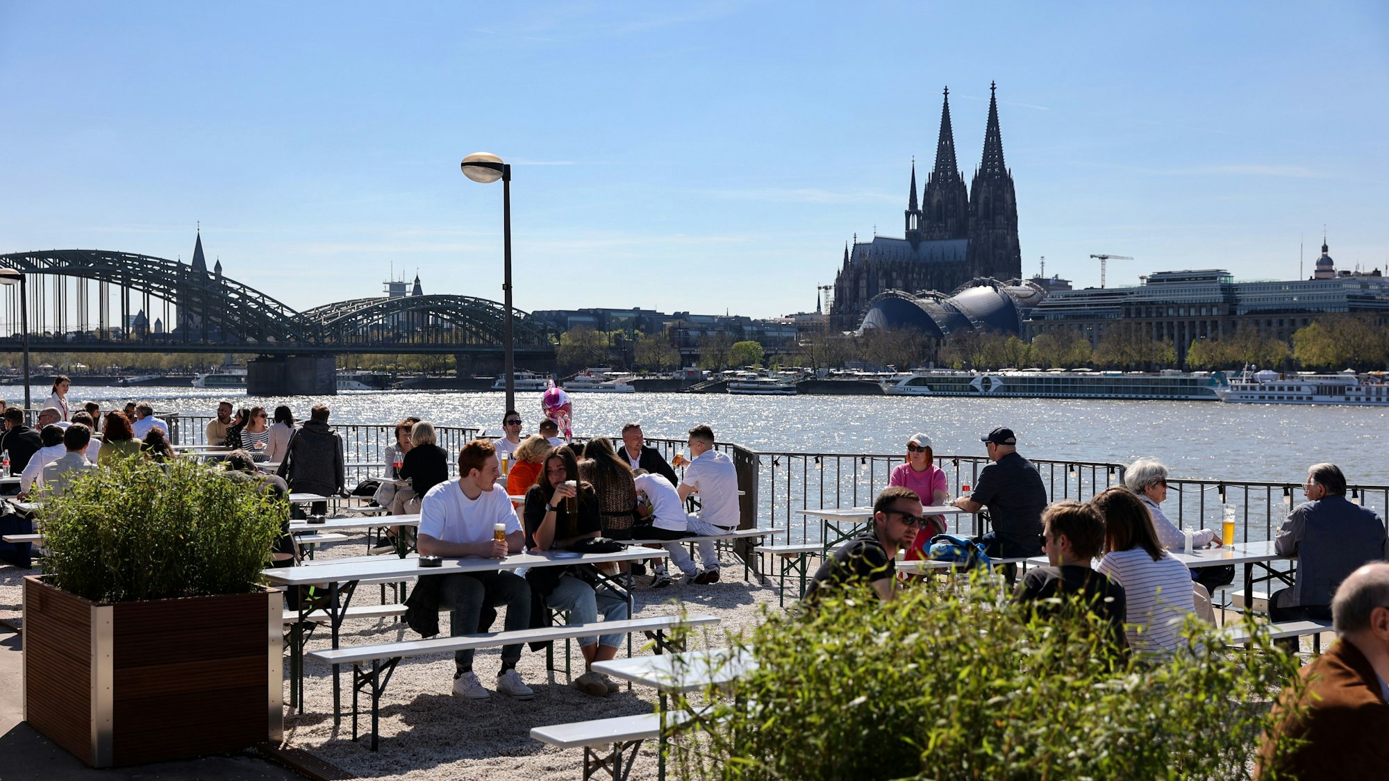 Gäste sitzen im Sommer im Biergarten der Rheinterrassen.