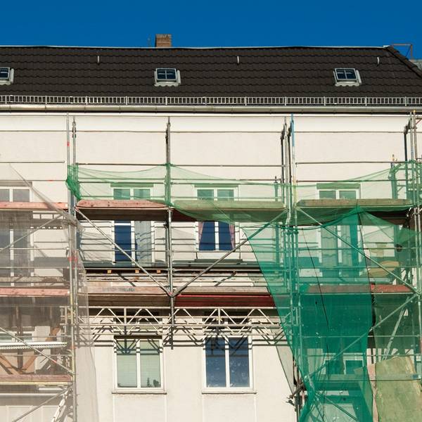 Ein großes Mietshaus ist eingerüstet.