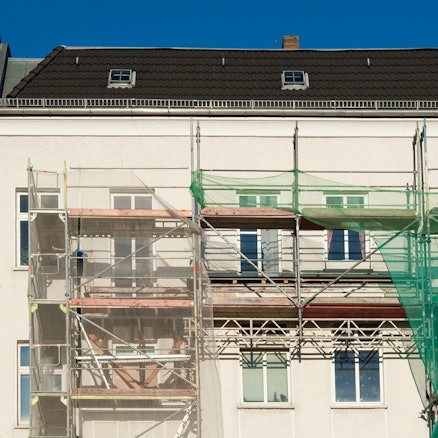 Ein großes Mietshaus ist eingerüstet.