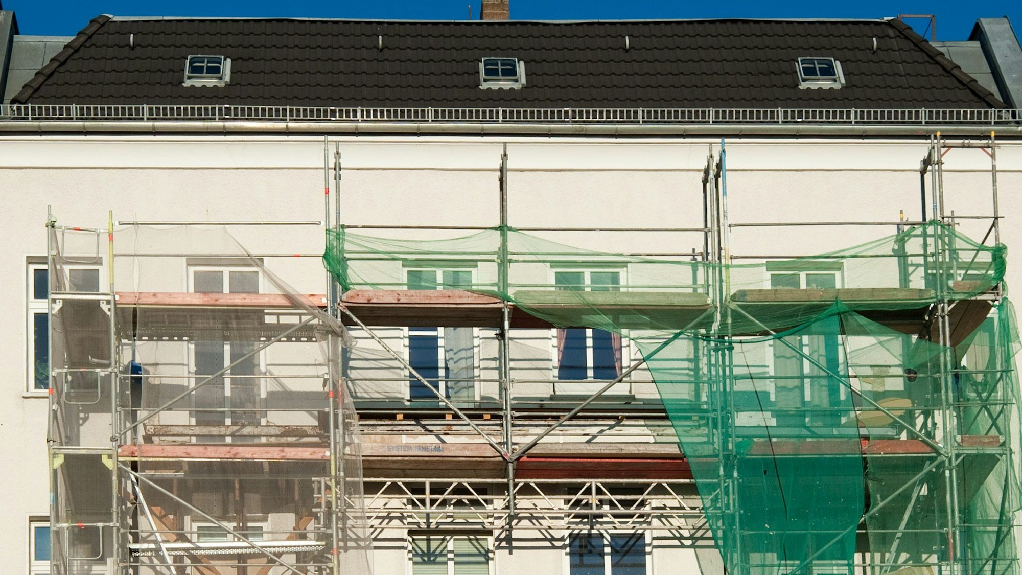 Ein großes Mietshaus ist eingerüstet.