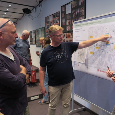 Drei Teilnehmer stehen vor einer Straßenkarte.