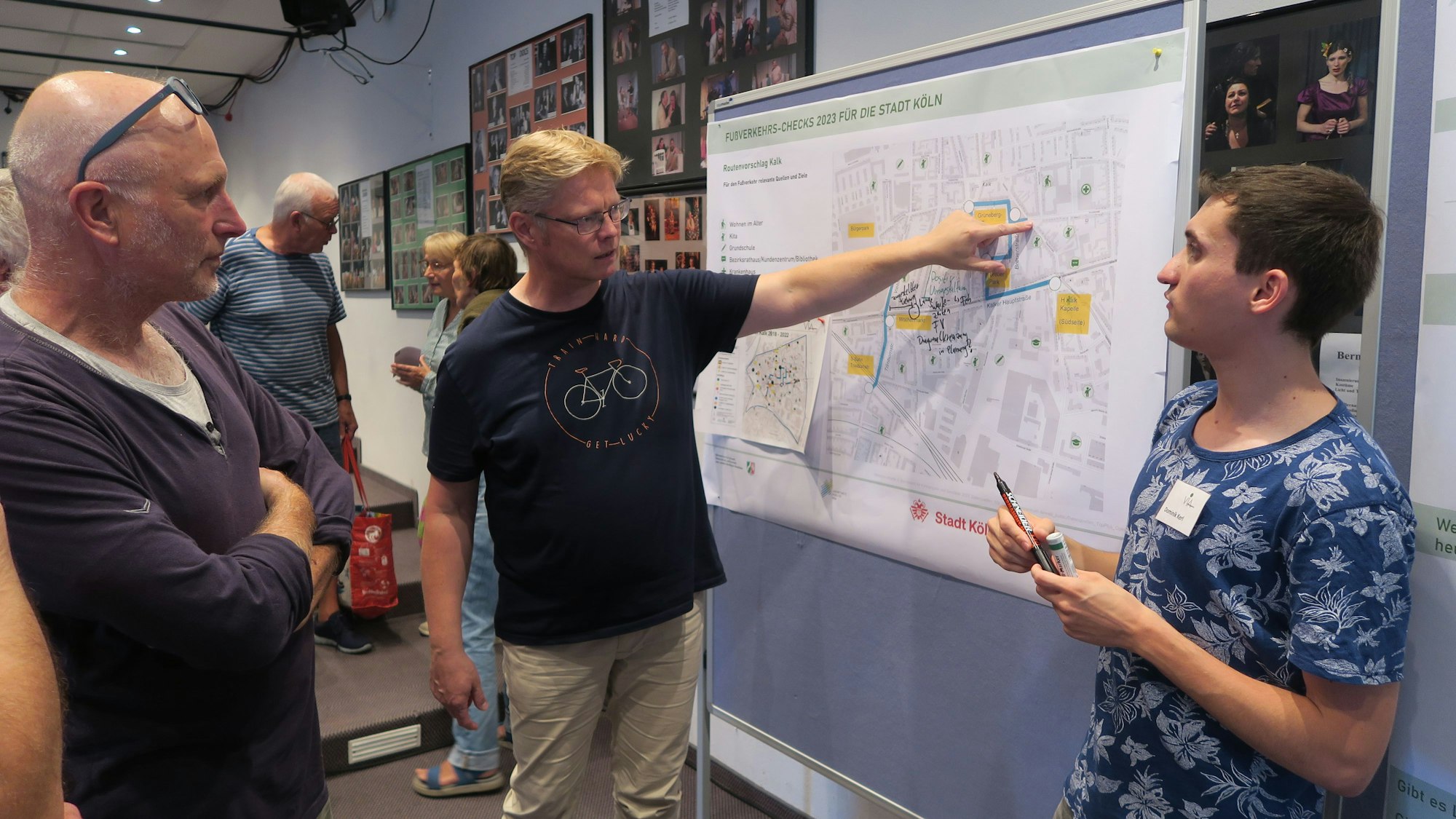 Drei Teilnehmer stehen vor einer Straßenkarte.