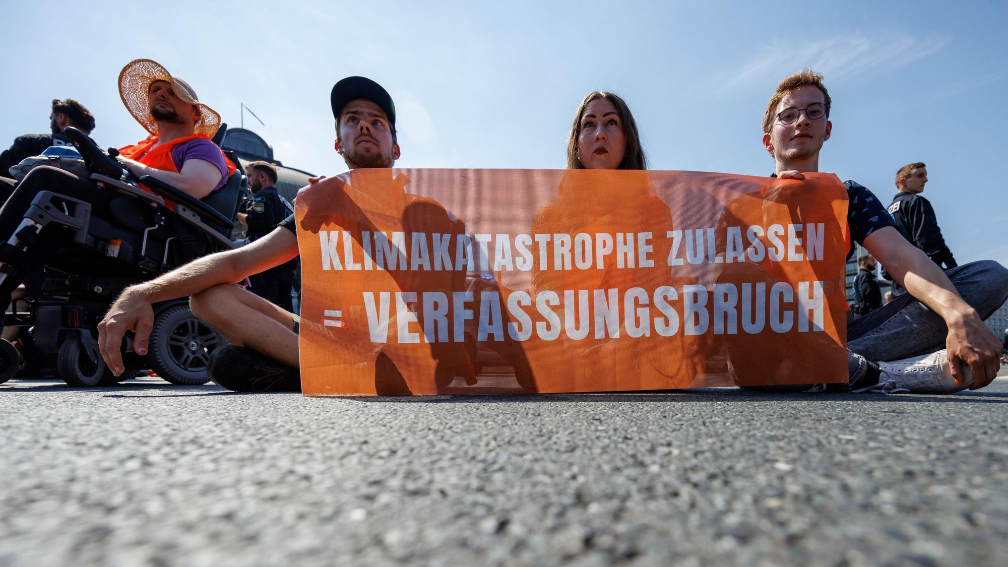Zu sehen sind Aktivisten der Klimaschutzorganisation «Letzte Generation», sie protestieren mit einem Banner mit der Aufschrift «Klimakatastrophe zulassen = Verfassungsbruch?».