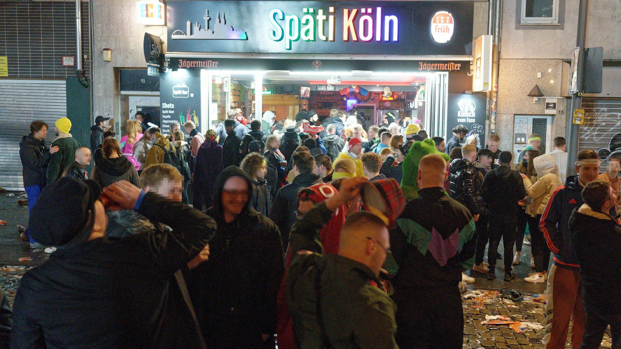 Feiernde stehen im Februar 2022 vor einer Kneipe am Zülpicher Platz.
