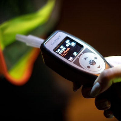 Eine FPolizistin hält ein Gerät in der Hand, mit dem Atemalkoholtests durchgeführt werden.