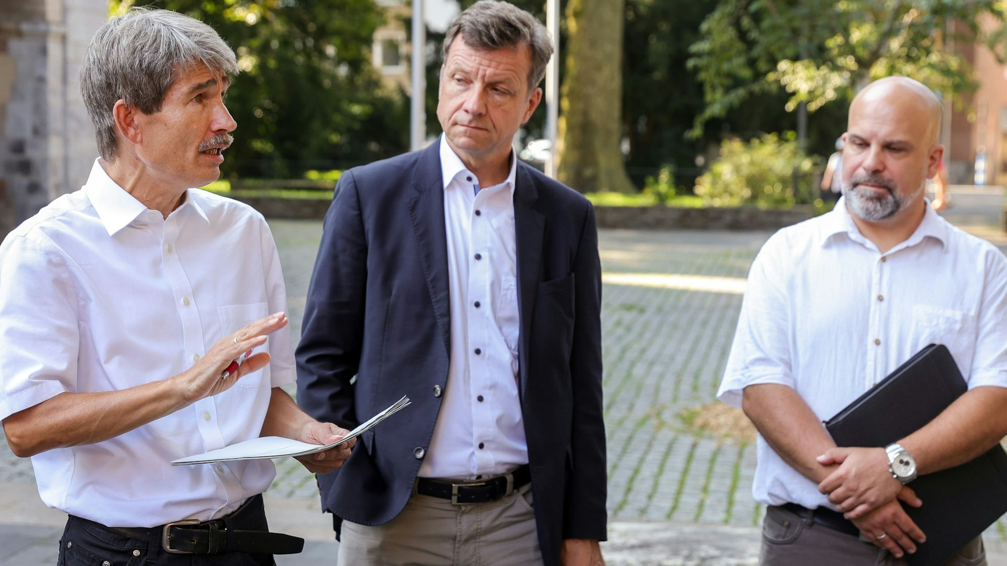 Zu sehen sind von links nach rechts Dr. Ulrich Höver, Ascan Egerer und Markus Rosellen beim Ortstermin der Bezirksvertretung Innenstadt auf dem Platz zwischen St. Gereon und dem Hotel The Qvest.