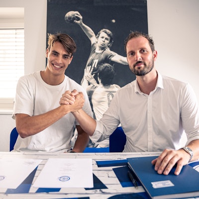 Handballer Julian Köster und VfL-Geschäftsführer Christoph Schindler sitzen nebeneinander und schlagen mit den Händen ein.
