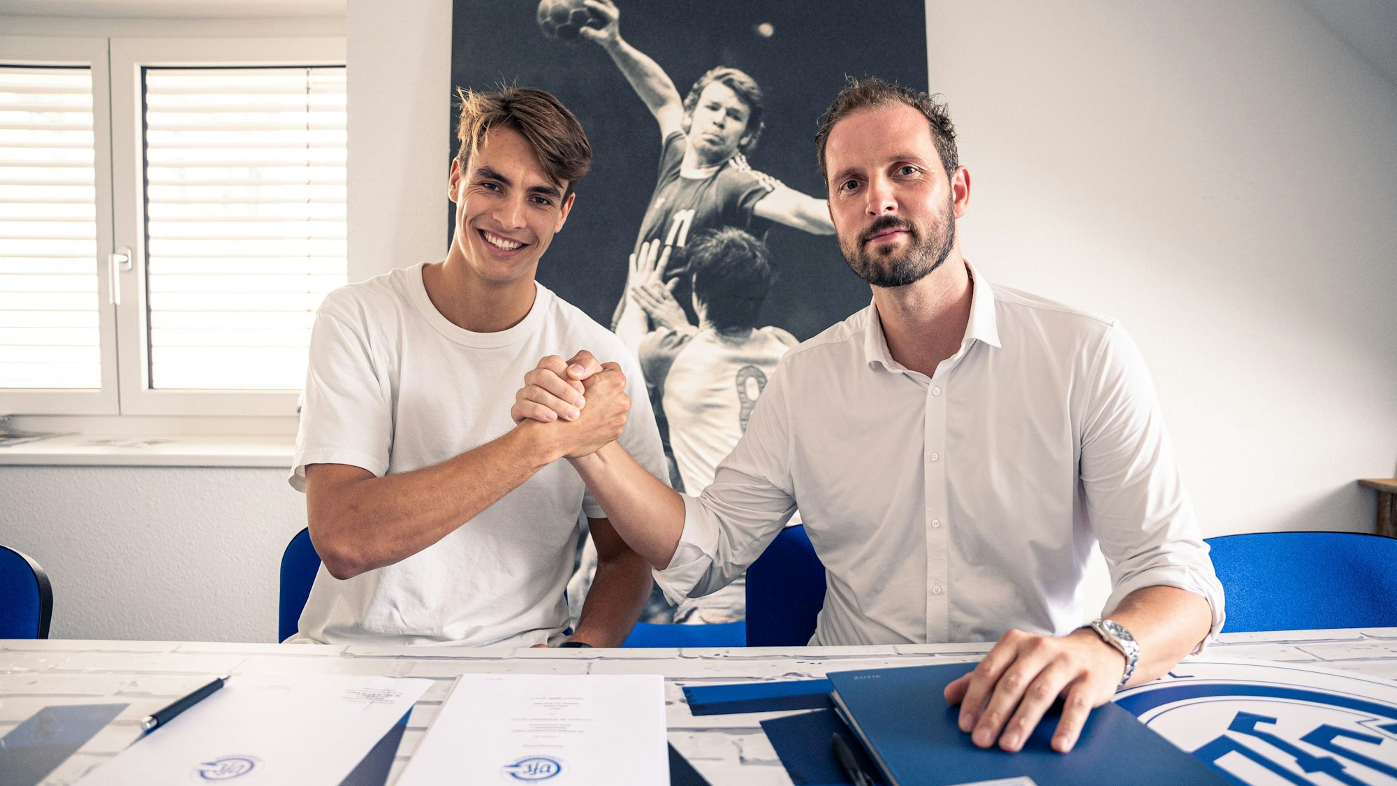 Handballer Julian Köster und VfL-Geschäftsführer Christoph Schindler sitzen nebeneinander und schlagen mit den Händen ein.