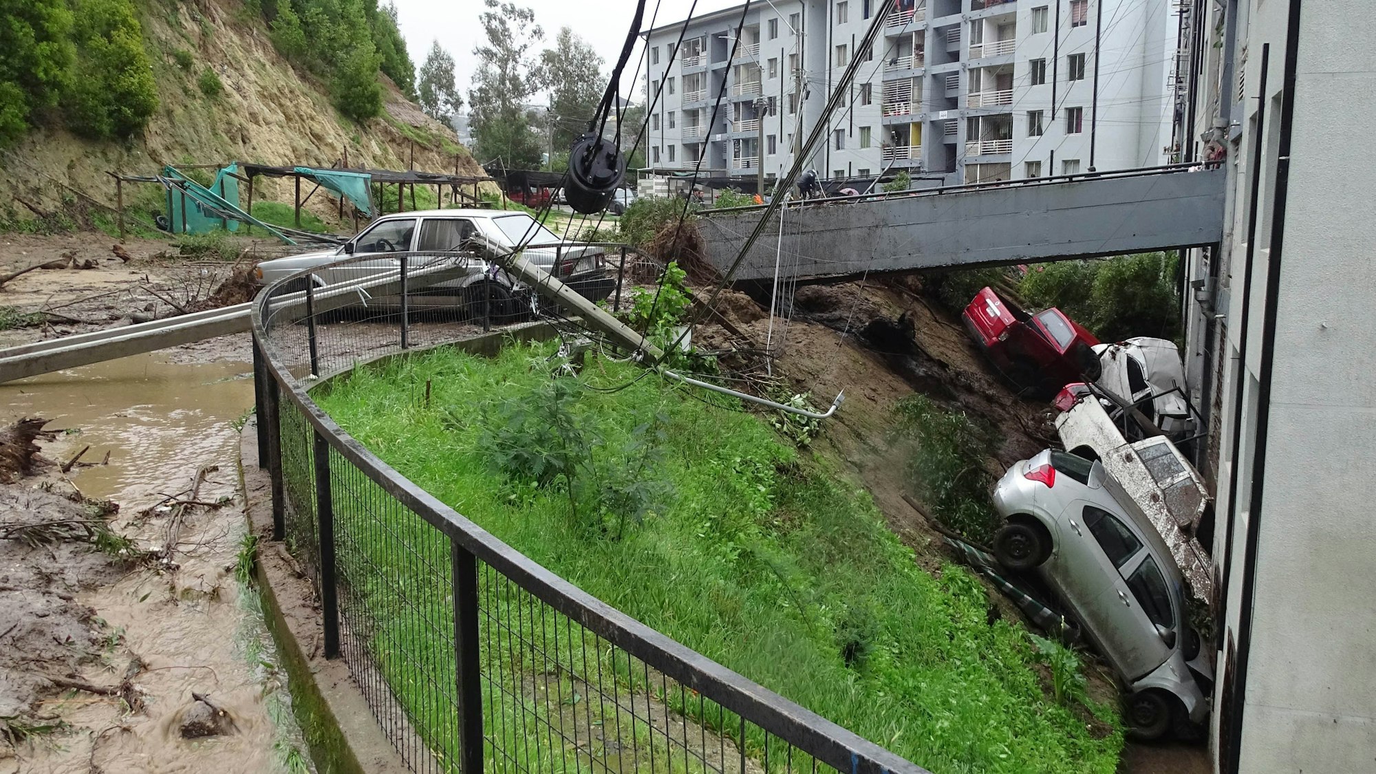 21.08.2023, Chile, Constitucion: Autos, die von einem durch starke Regenfälle verursachten Erdrutsch in Constitucion weggeschwemmt wurden, sind gegen ein Gebäude geprallt.