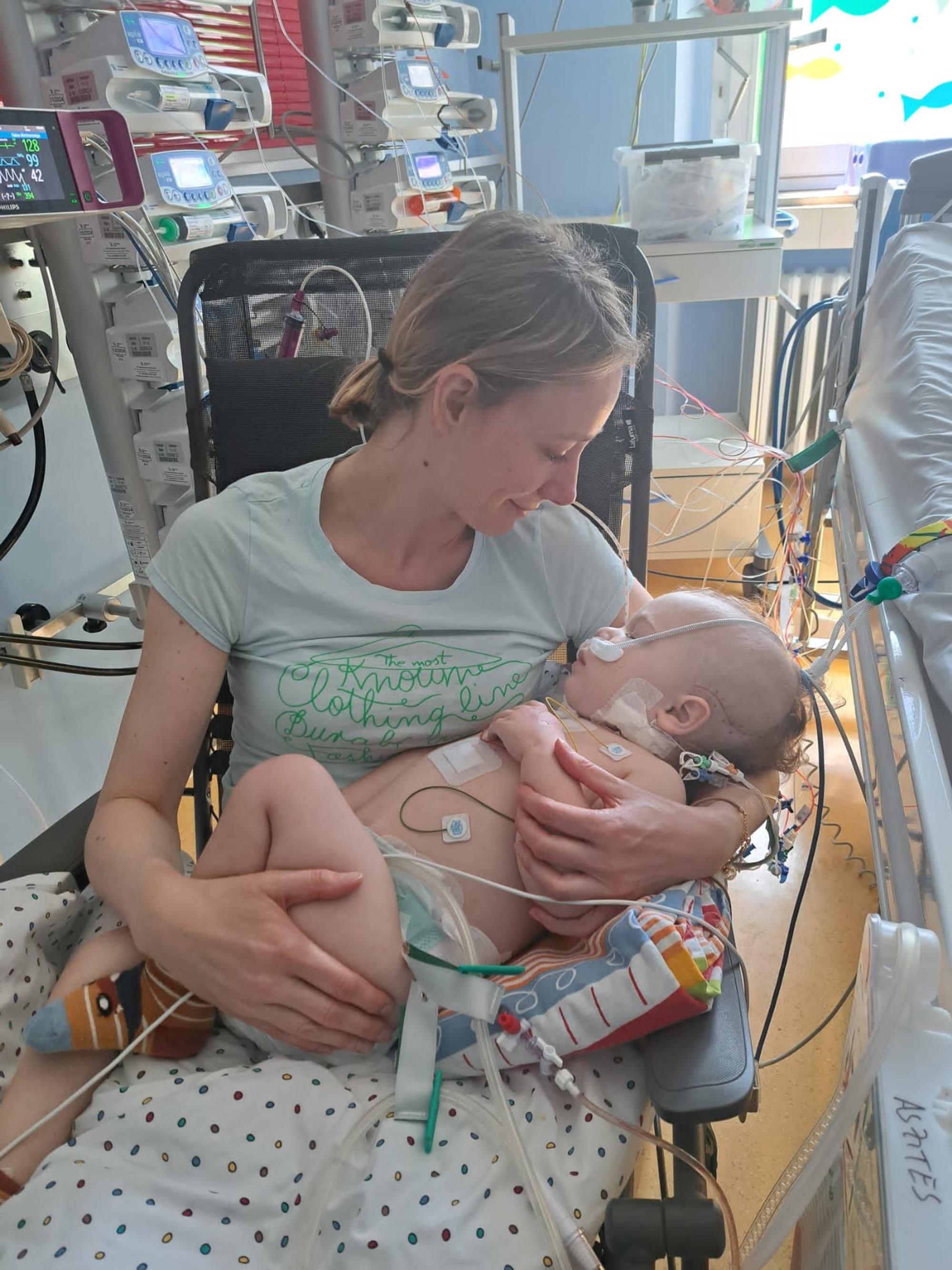 Mutter Eva-Maria Kütting hält ihr Kind Francesco nach der OP im Arm: Das Kind ist mit zahlreichen Sonden und Schläuchen verkabelt.