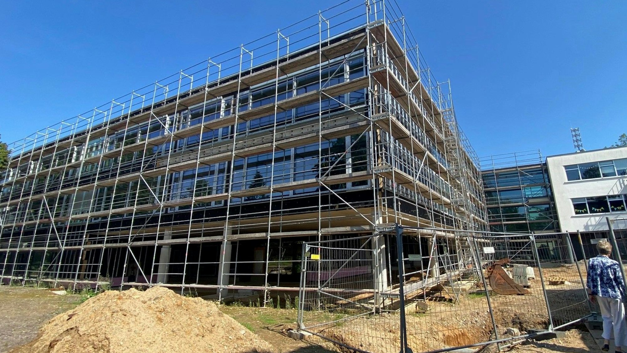 Das Bild zeigt den dreigeschossigen Neubau der Schule, der noch von einem Gerüst umgeben ist.