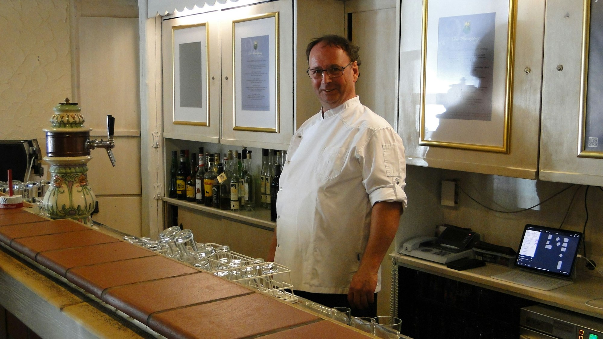Ein Wirt hinter der Theke.
