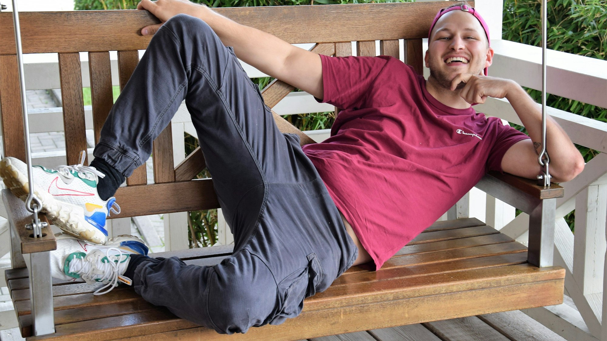 Das Foto zeigt David Leischik. Er hat es sich auf einer Holzbank gemütlich gemacht.