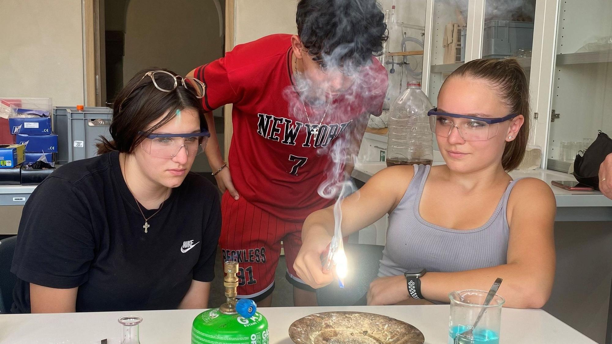 Zoe, Julian und Melissa (v.l.) testen, wie Magnesium brennt.