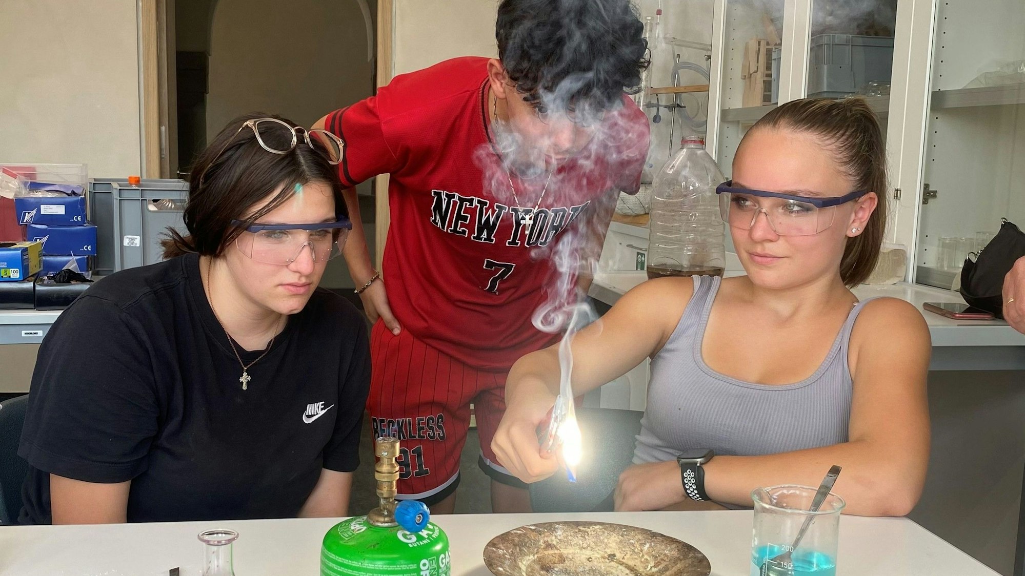Zoe, Julian und Melissa (v.l.) testen, wie Magnesium brennt.