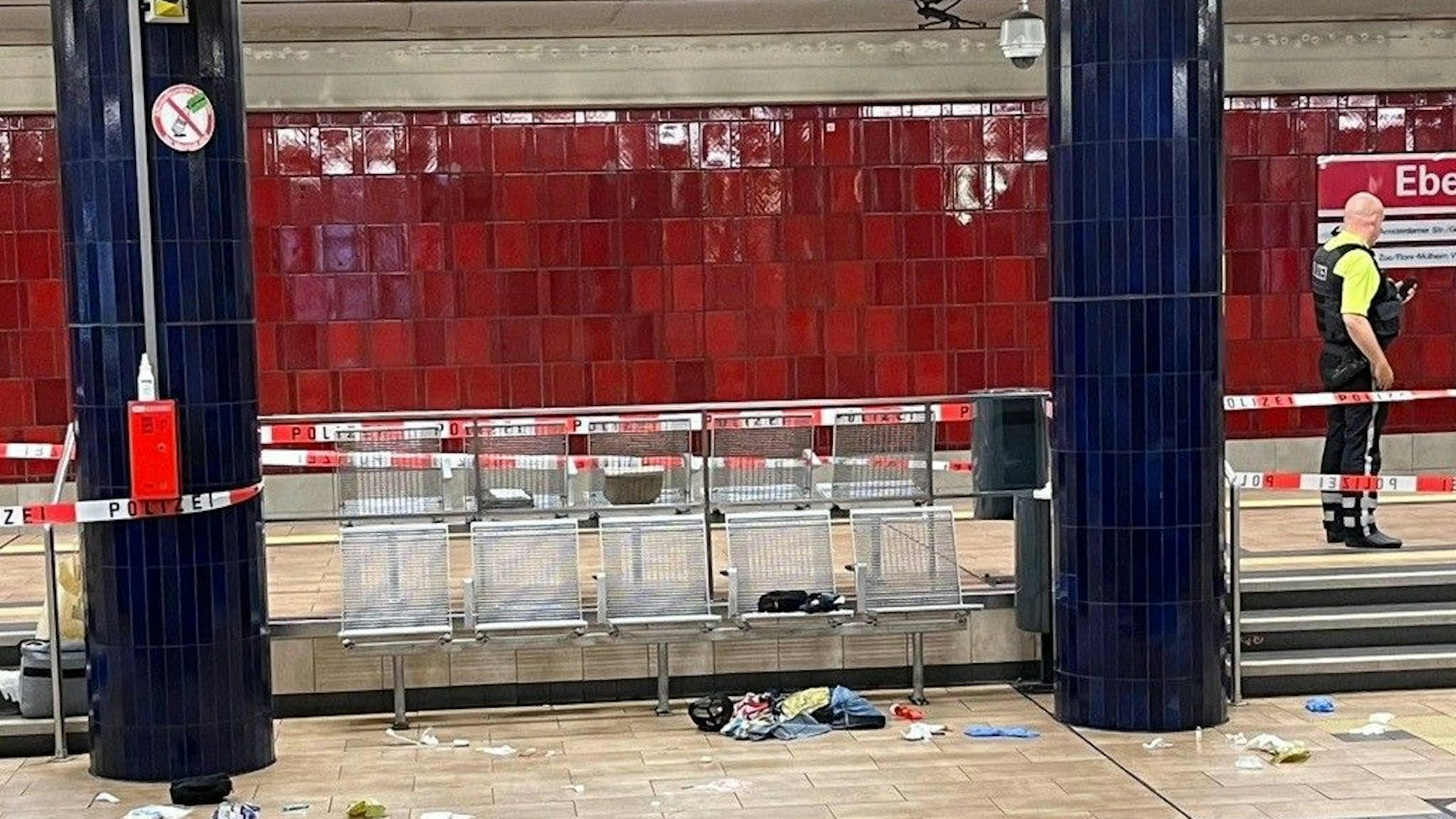 Auf dem U-Bahnsteig der KVB-Haltestelle Ebertplatz wurde am Dienstag, 22. August 2023, ein 28 Jahre alter Mann niedergestochen. Ein Polizist sichert die Stelle ab.