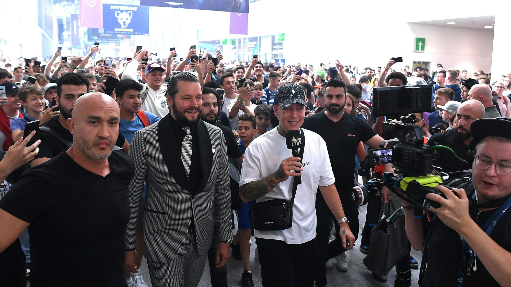 Die beiden Social-Media-Stars Marcel Eris, bekannt als MontanaBlack, und Marc Gebauer laufen im August 2022 über das Gamescom-Gelände in Köln und berichten per Livestream.