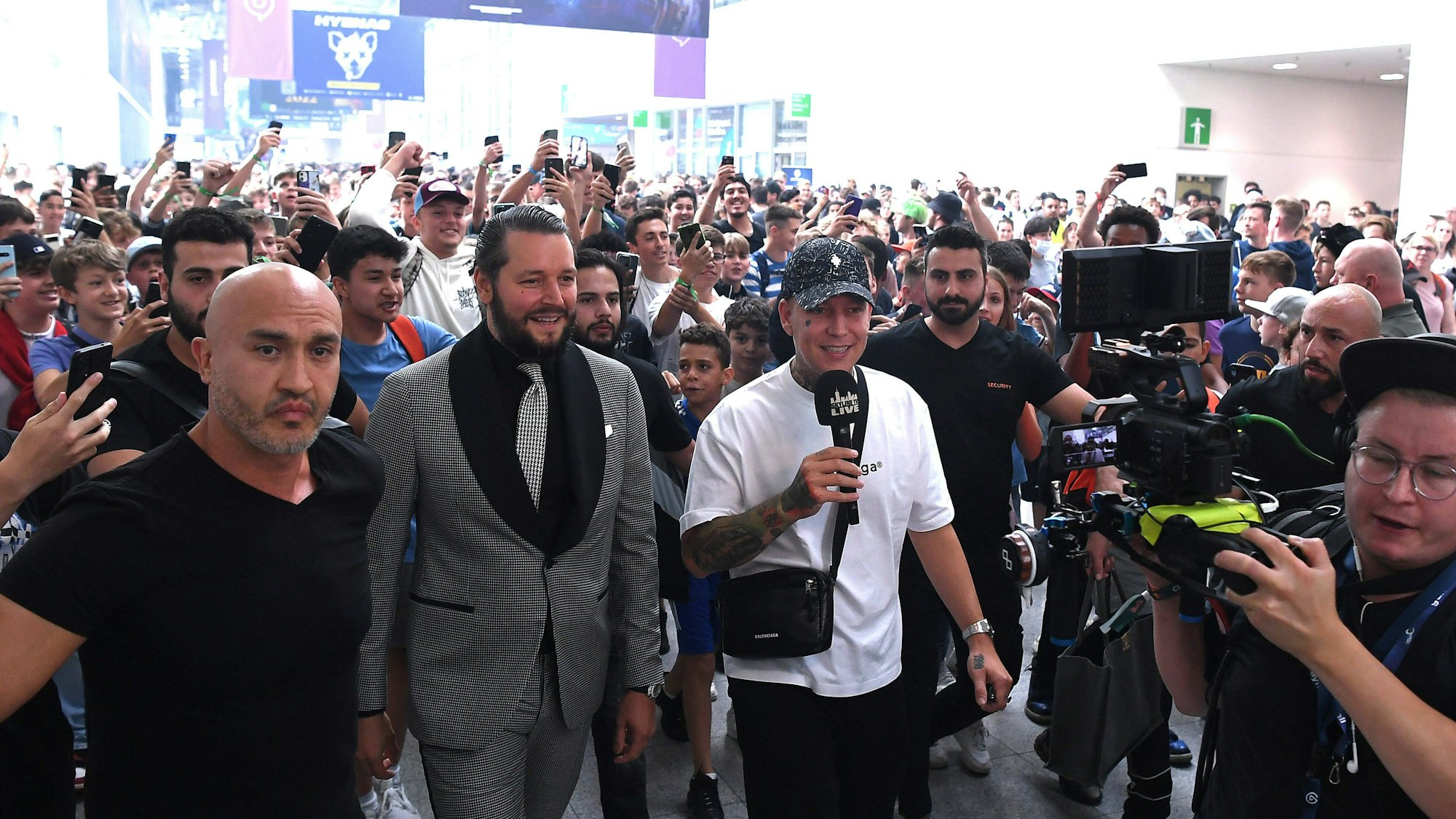 Die beiden Social-Media-Stars Marcel Eris, bekannt als MontanaBlack, und Marc Gebauer laufen im August 2022 über das Gamescom-Gelände in Köln und berichten per Livestream.