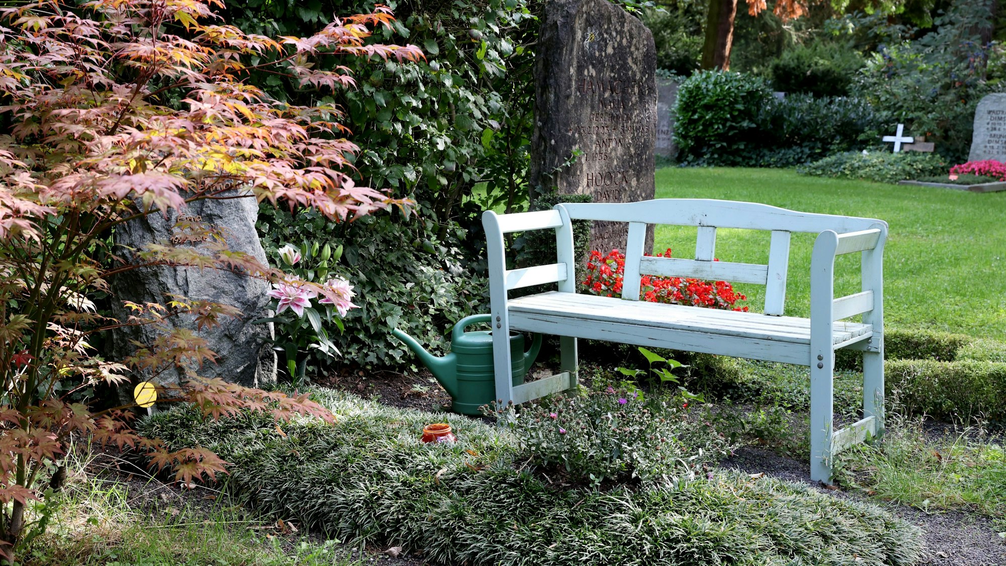 Eine weiße Bank auf dem Melatenfriedhof