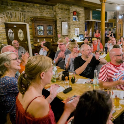 Zuschauerinnen und Zuschauer klatschen in die Hände.