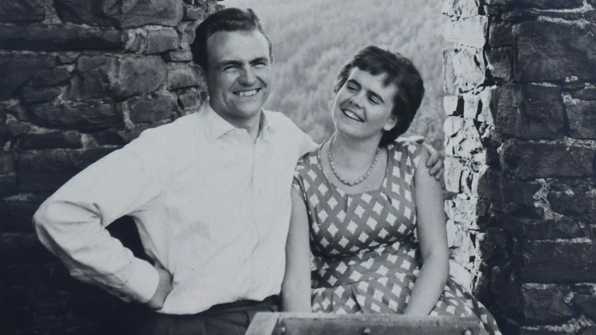 Ein altes schwarz-weißes Foto zeigt zwei junge Menschen, wie sie gemeinsam lachen.