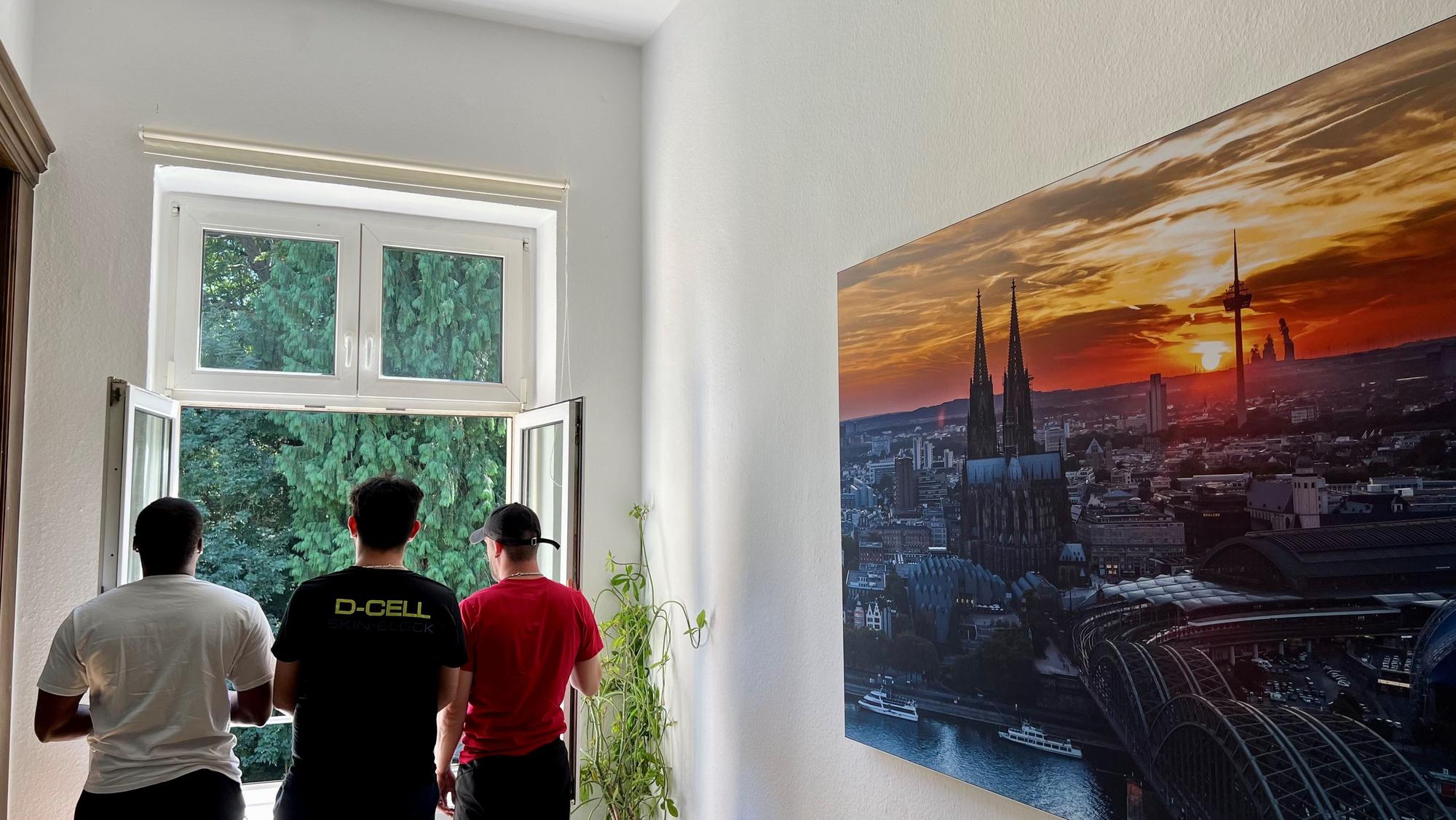 Drei Männer schauen aus dem Fenster.