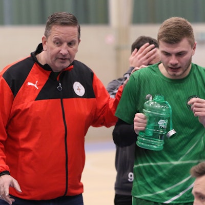 Das Bild zeigt Trainer Olaf Pohlmeier, wie er mit seinem Teil seiner Spieler spricht.