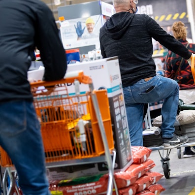 Das Foto zeigt Kunden mit ihren Einkaufswagen in einem Baumarkt.