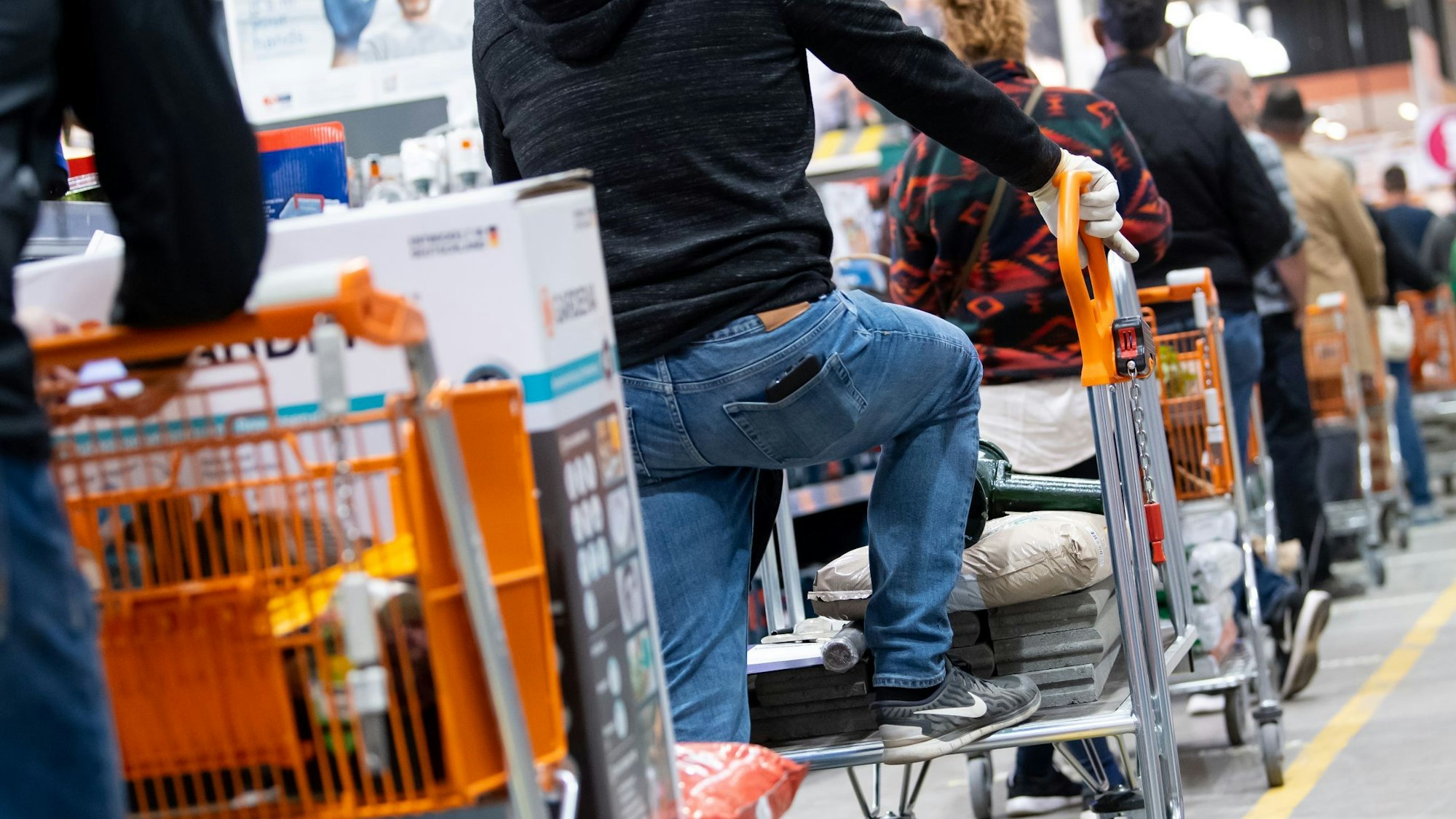 Das Foto zeigt Kunden mit ihren Einkaufswagen in einem Baumarkt.