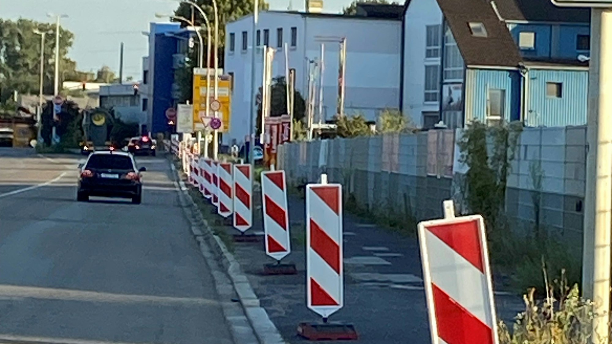 Am Rand einer Straße stehen Warnbaken aufgereiht.