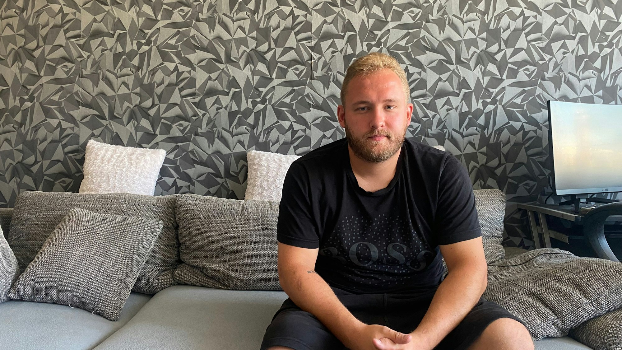 Kevin Niestroj sitzt auf einem Sofa