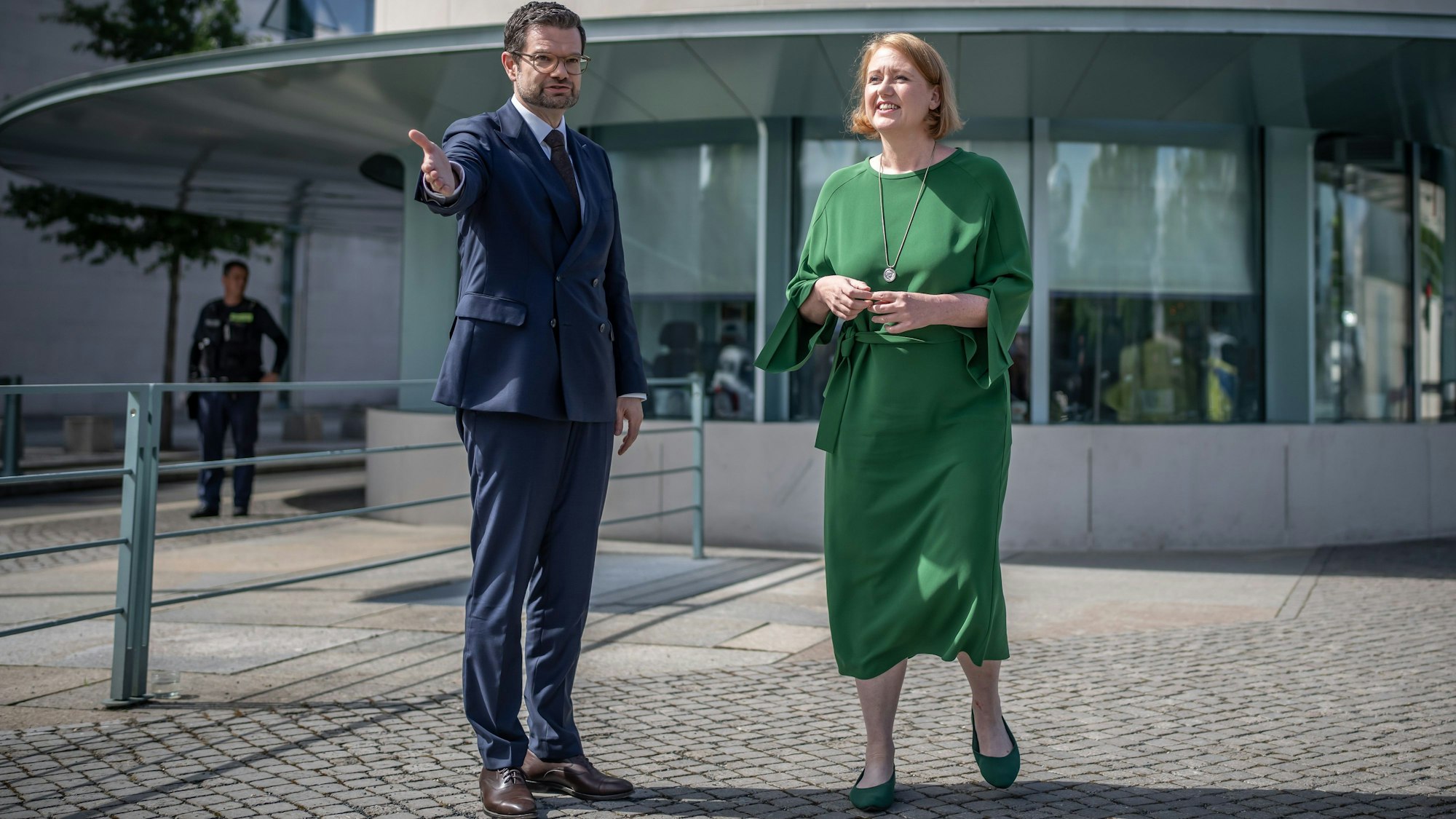 Lisa Paus und Marco Buschmann stehen vor einem kreisrunden Gebäude.