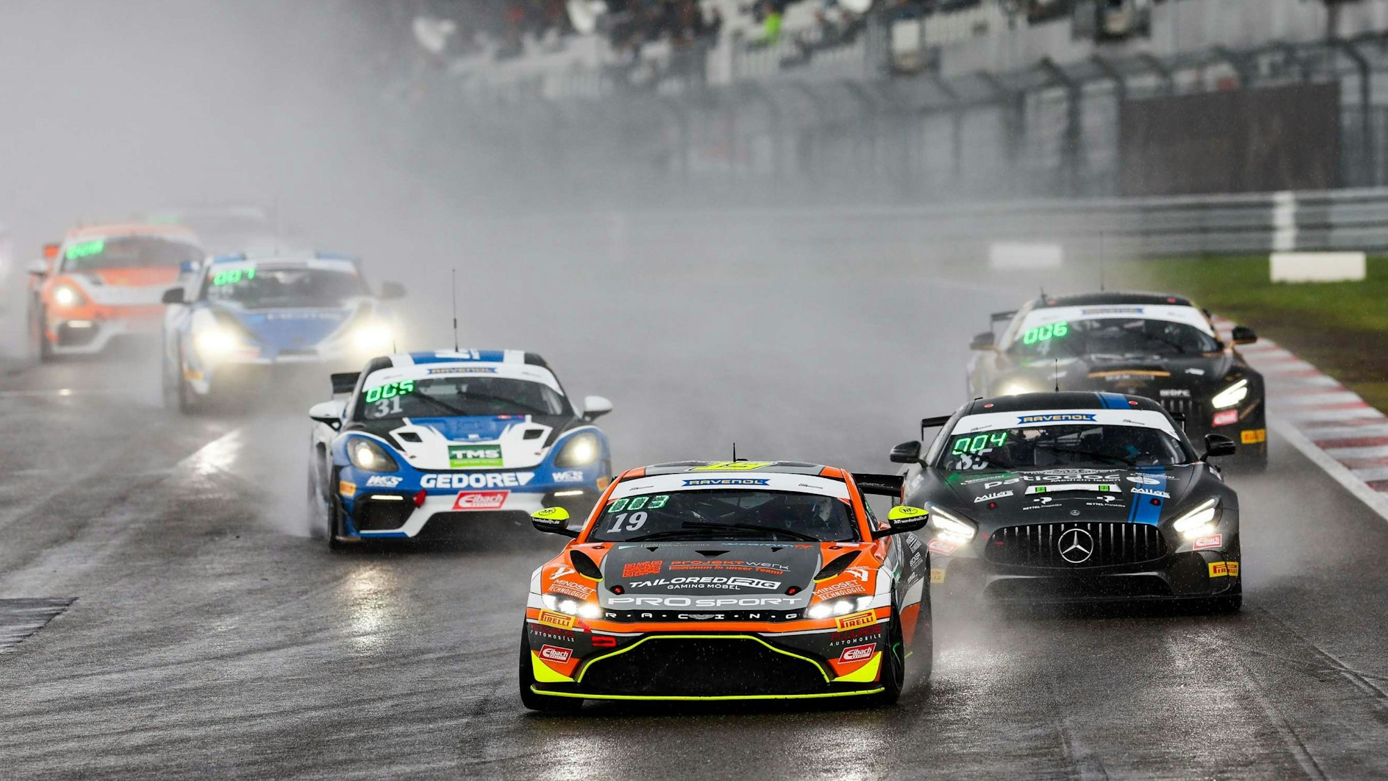 Bild mehrerer Rennautos im Regen.