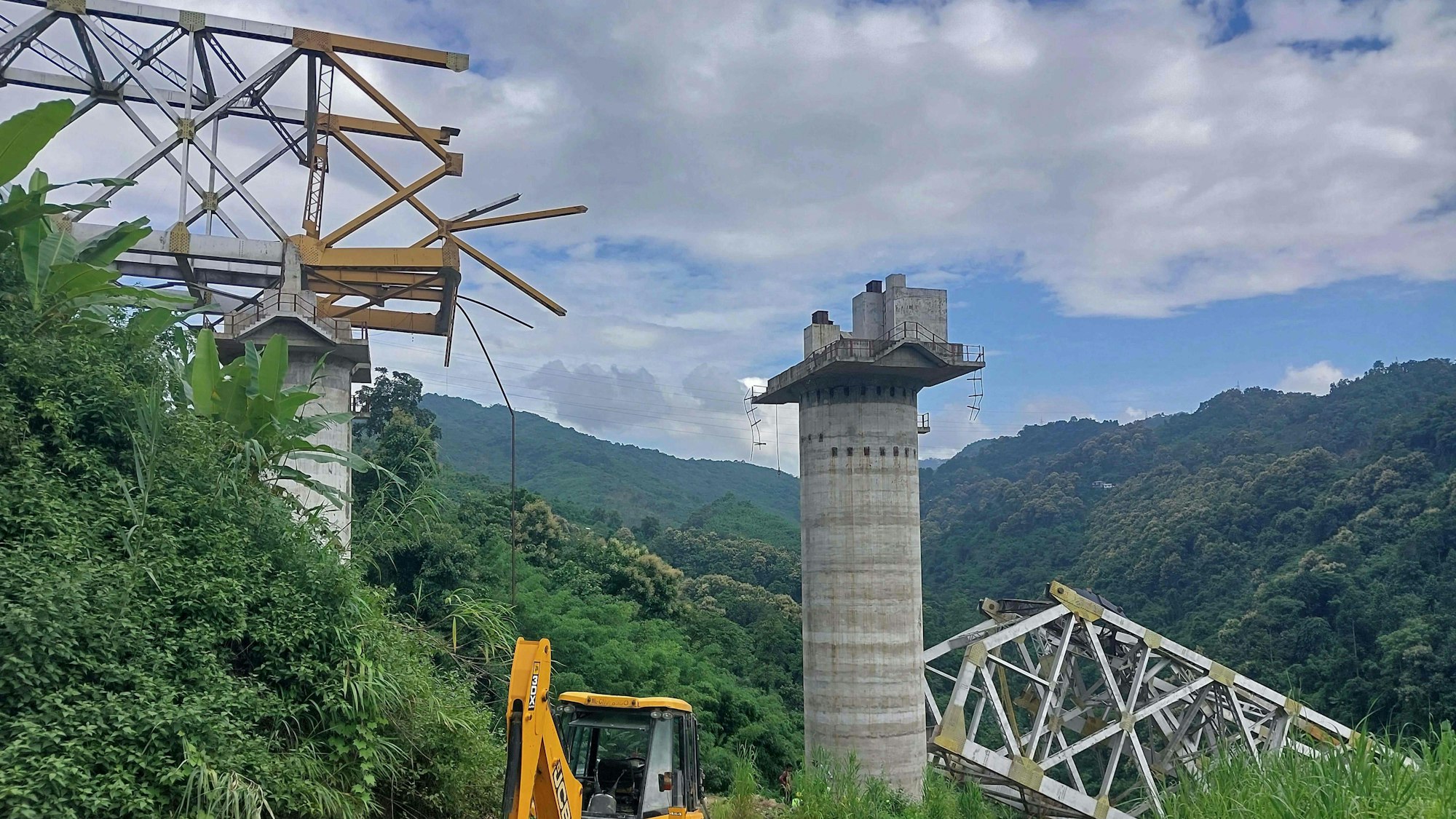 afpRescue workers conduct a search operation at the site of an accident where an under-construction railway bridge collapsed in Sairang town of the Aizwal district in India's eastern state of Mizoram. At least 17 labourers working on a railway bridge being built across a ravine in India's eastern Mizoram state were killed when it collapsed on August 23, officials said, with others reported missing. (Photo by AFP)