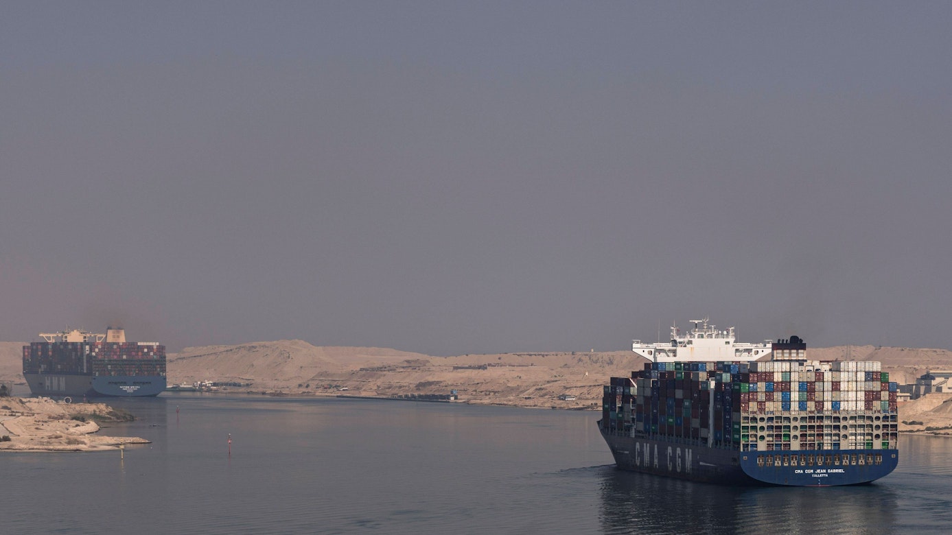 Zwei Frachtschiffe fahren durch den Suezkanal in Ägypten. Links und rechts vom Ufer ist Wüste zu sehen. (Symbolbild)